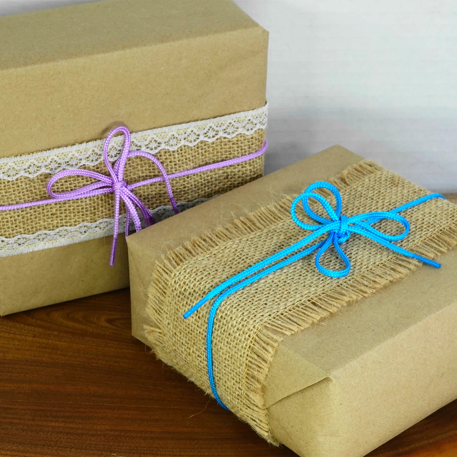 Two mystery boxes, one with pink ribbon, the other with blue ribbon.